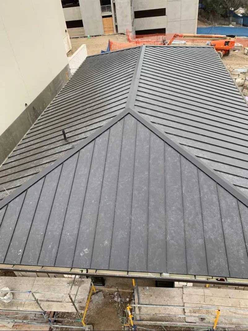 Commercial metal roof construction with crane equipment in Saranap